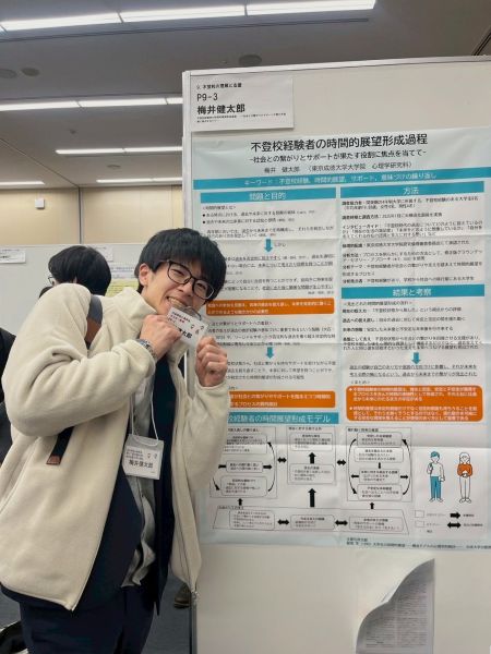 梅井さん ポスターの前で